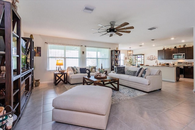 living room with ceiling fan, sink, and tile patterned floors