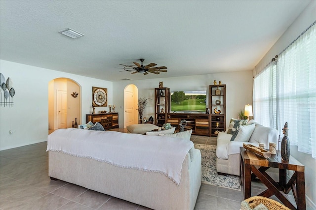 bedroom with ceiling fan, a textured ceiling, and tile patterned floors