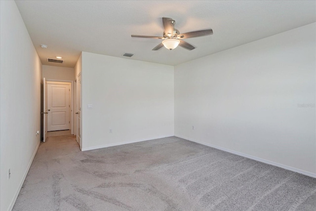 spare room featuring light colored carpet and ceiling fan