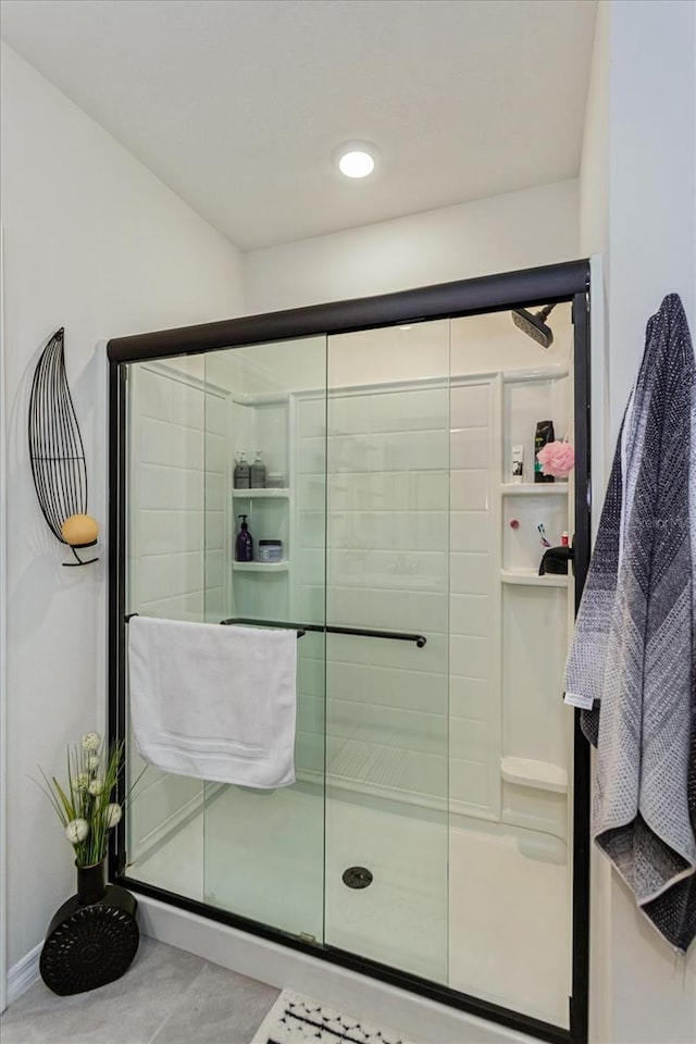 bathroom featuring a shower with door