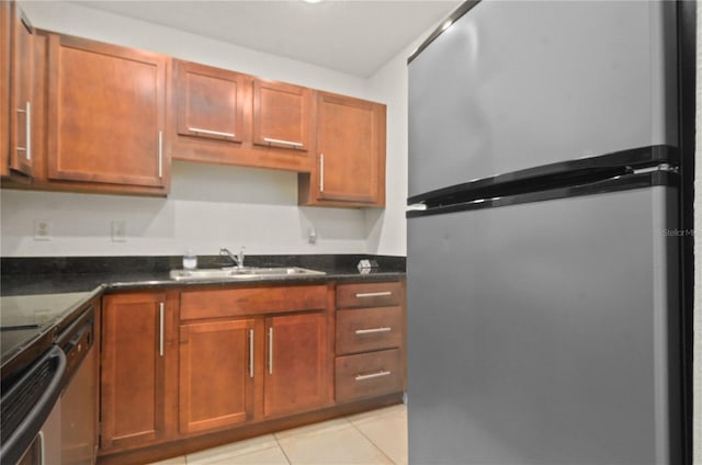 kitchen featuring appliances with stainless steel finishes, dark stone countertops, light tile patterned flooring, and sink