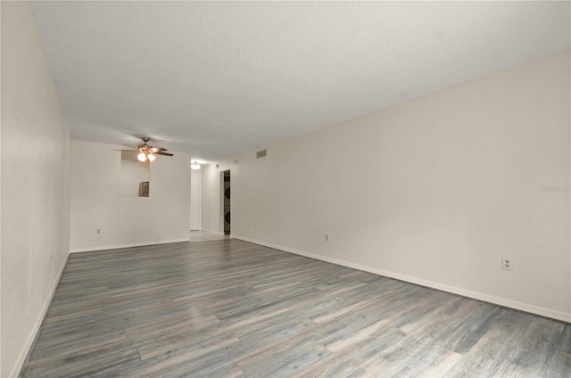 empty room with a textured ceiling, hardwood / wood-style floors, and ceiling fan