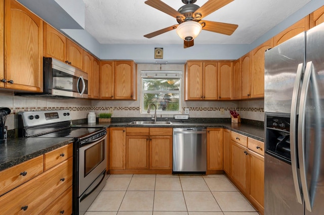 kitchen with stainless steel appliances, sink, light tile patterned flooring, ceiling fan, and tasteful backsplash