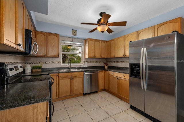 kitchen featuring light tile patterned floors, stainless steel appliances, sink, decorative backsplash, and ceiling fan