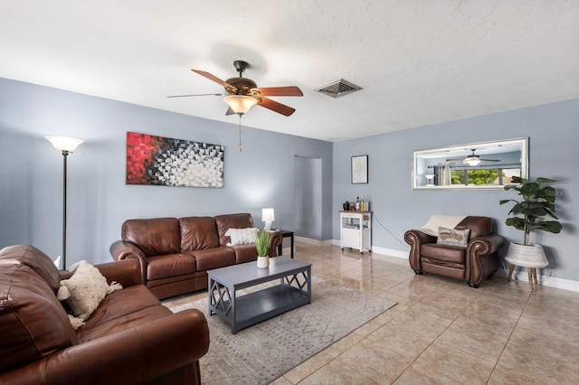 living room featuring ceiling fan and a textured ceiling