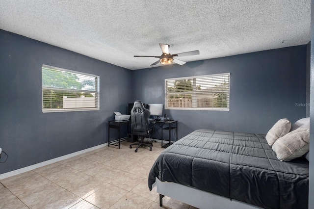 bedroom with multiple windows, ceiling fan, and a textured ceiling