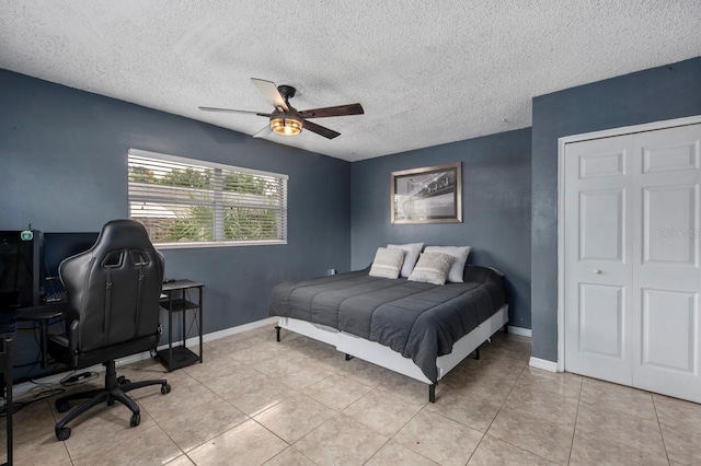 bedroom featuring ceiling fan, light tile patterned floors, and a textured ceiling