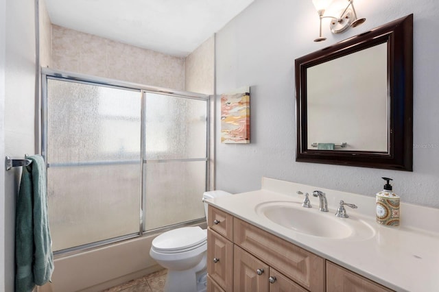 full bathroom featuring tile patterned flooring, toilet, bath / shower combo with glass door, and vanity