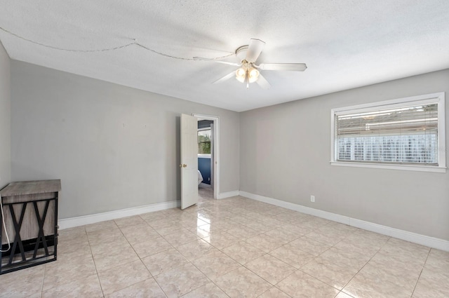 spare room with a textured ceiling and ceiling fan