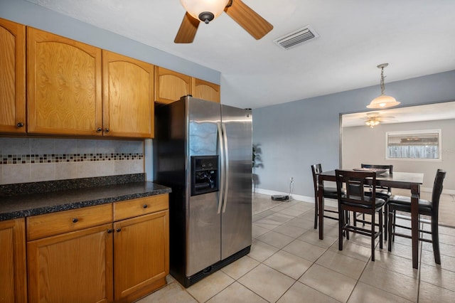 kitchen featuring decorative light fixtures, stainless steel refrigerator with ice dispenser, light tile patterned floors, backsplash, and ceiling fan