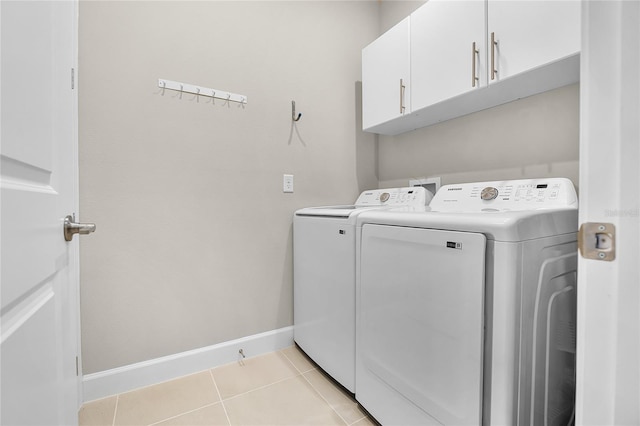 washroom with cabinets, washer and clothes dryer, and light tile patterned flooring