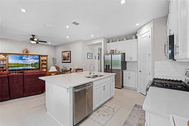 kitchen featuring a kitchen island with sink, stainless steel appliances, sink, ceiling fan, and light tile patterned flooring