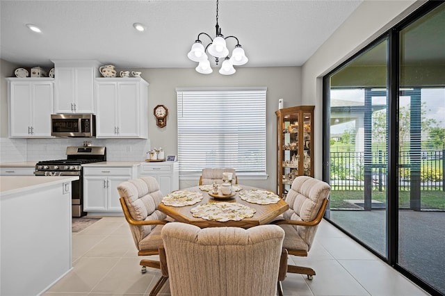 dining space featuring a wealth of natural light, light tile patterned flooring, and a notable chandelier