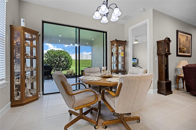 tiled dining area with ceiling fan with notable chandelier