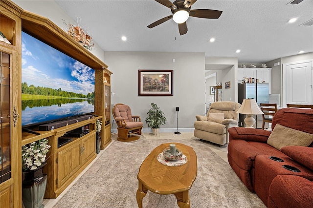 living room featuring a textured ceiling and ceiling fan