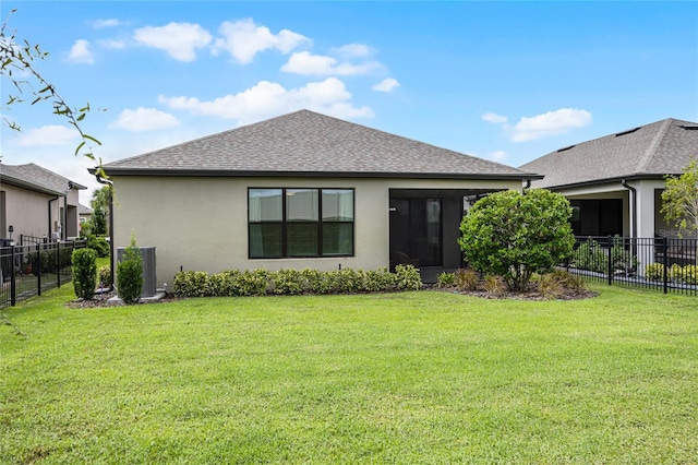 rear view of house featuring a lawn and central AC unit