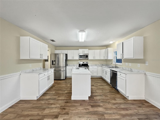 kitchen featuring white cabinetry, dark hardwood / wood-style flooring, a center island, sink, and appliances with stainless steel finishes