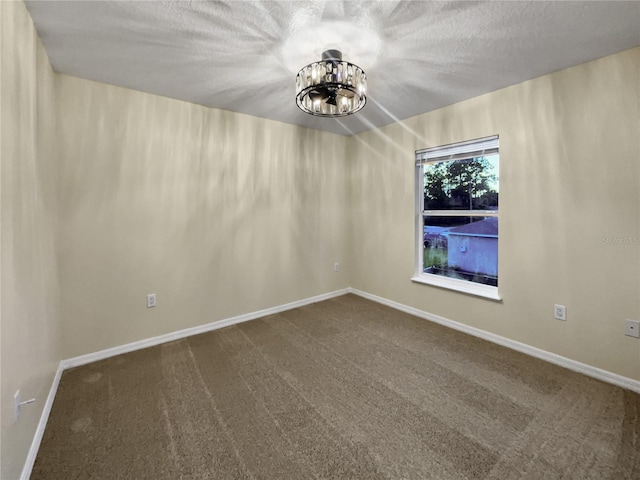 spare room featuring a textured ceiling and carpet flooring