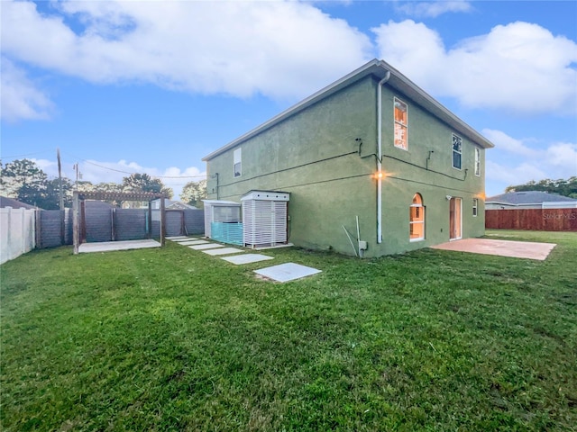 back of property with a patio area and a yard