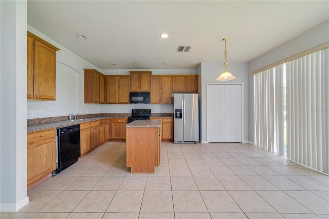 kitchen with decorative light fixtures, light tile patterned floors, black appliances, a kitchen island, and sink