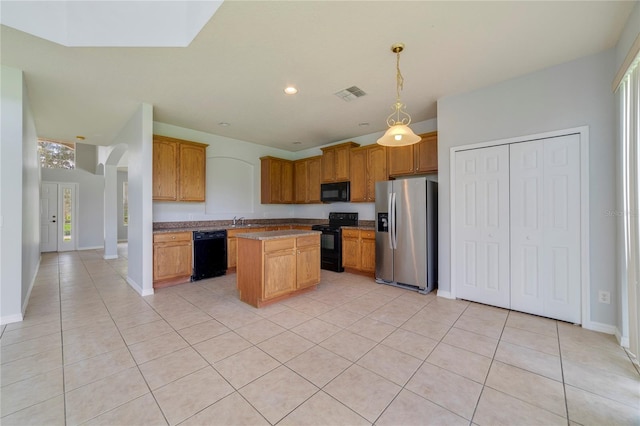 kitchen with a kitchen island, decorative light fixtures, black appliances, light tile patterned floors, and sink