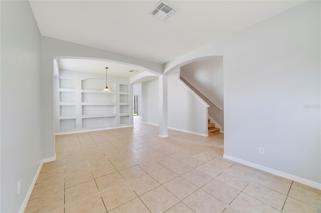 tiled empty room featuring built in shelves