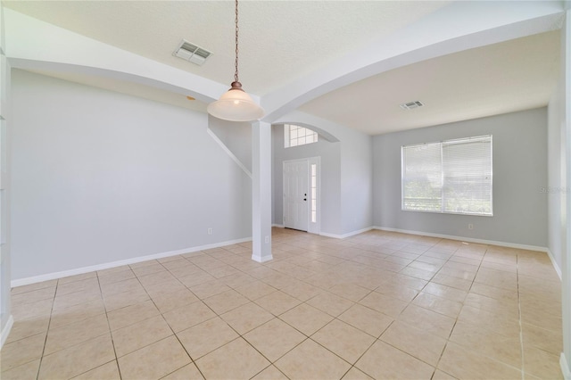 empty room featuring a textured ceiling and light tile patterned flooring