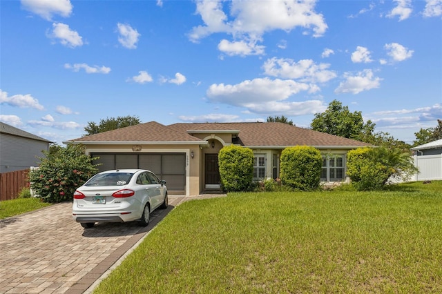 ranch-style home with a garage and a front lawn