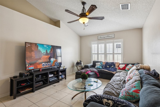 living room with lofted ceiling, ceiling fan, a textured ceiling, and light tile patterned flooring