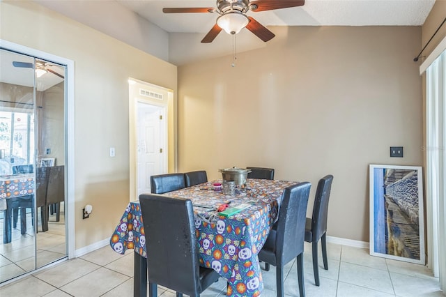 dining space featuring lofted ceiling, ceiling fan, and light tile patterned floors