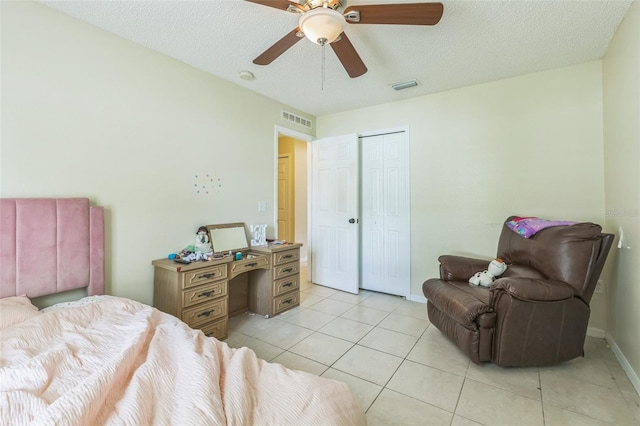 tiled bedroom featuring a textured ceiling, ceiling fan, and a closet