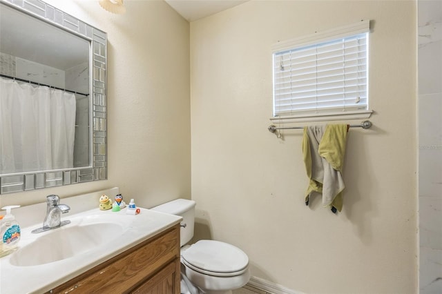 bathroom with walk in shower, toilet, and vanity