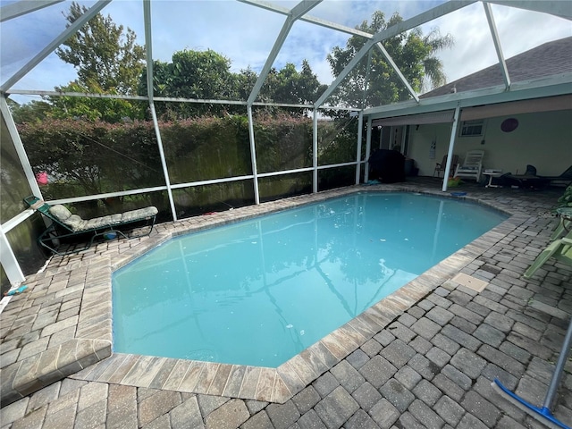 view of pool featuring glass enclosure and a patio