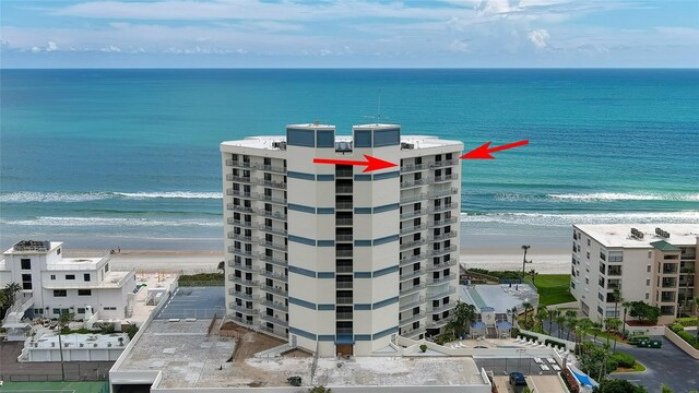 aerial view with a water view and a beach view