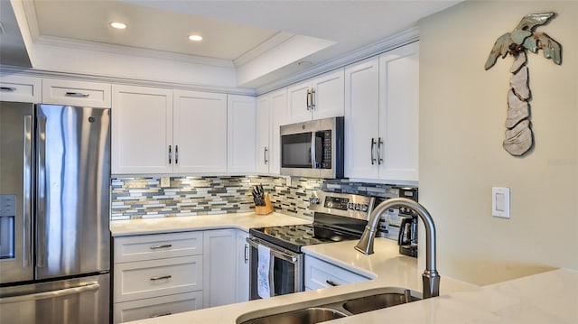 kitchen featuring stainless steel appliances, ornamental molding, and white cabinetry