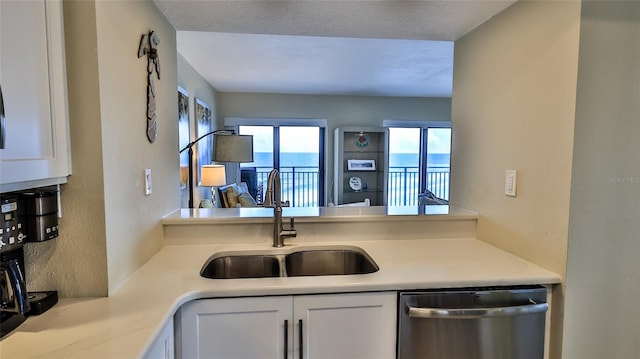 kitchen featuring white cabinets, dishwasher, a textured ceiling, and sink