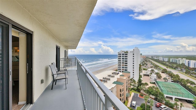 balcony featuring a water view and a beach view