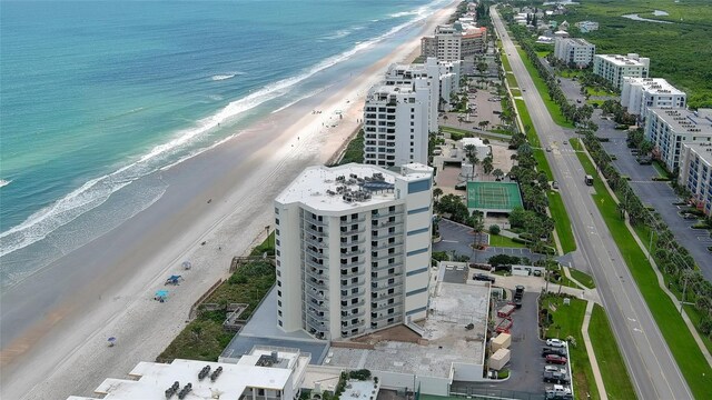 birds eye view of property with a water view and a view of the beach