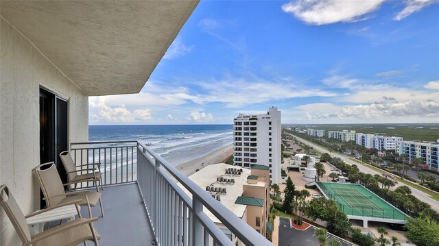 balcony featuring a view of the beach and a water view