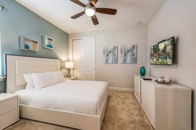 carpeted bedroom featuring ceiling fan and a closet