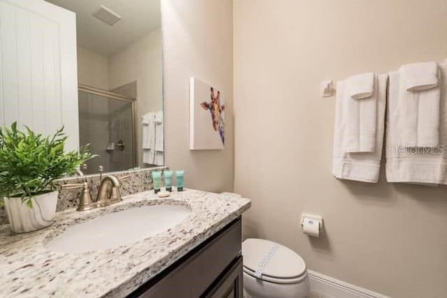 bathroom with vanity, toilet, and an enclosed shower