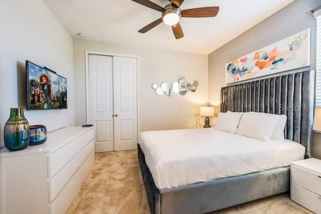 carpeted bedroom featuring a closet and ceiling fan