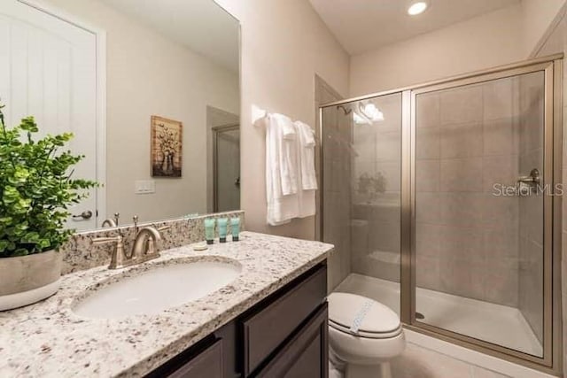 bathroom with toilet, a shower with door, and vanity