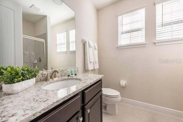 bathroom featuring vanity, toilet, a shower with shower door, and tile patterned flooring