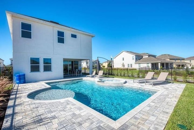 back of house featuring a patio and a pool with hot tub