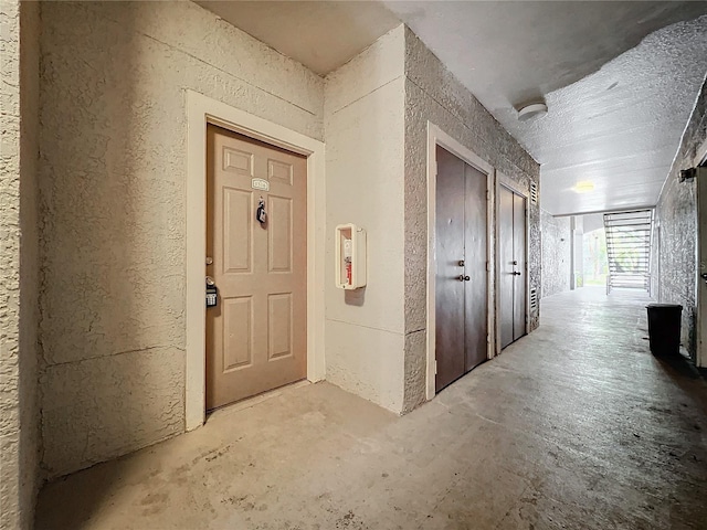 hall with a textured ceiling and concrete flooring