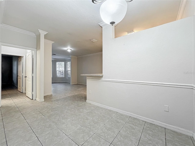 empty room with crown molding and light tile patterned floors