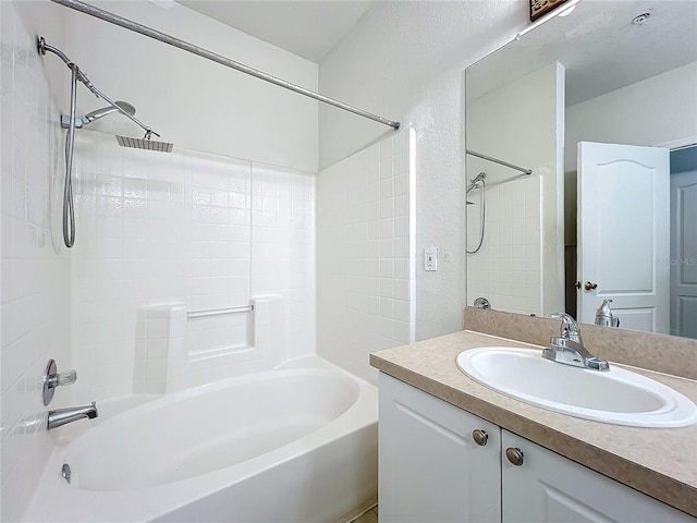 bathroom featuring tiled shower / bath and vanity