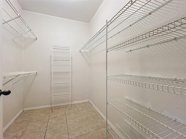 walk in closet with light tile patterned floors