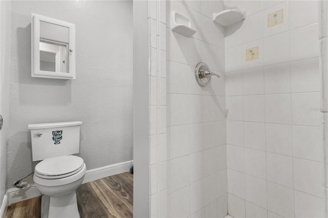 701 N Grandview Ave, Daytona Beach, FL 32118 - bathroom with wood finished floors, toilet, a tile shower, and baseboards